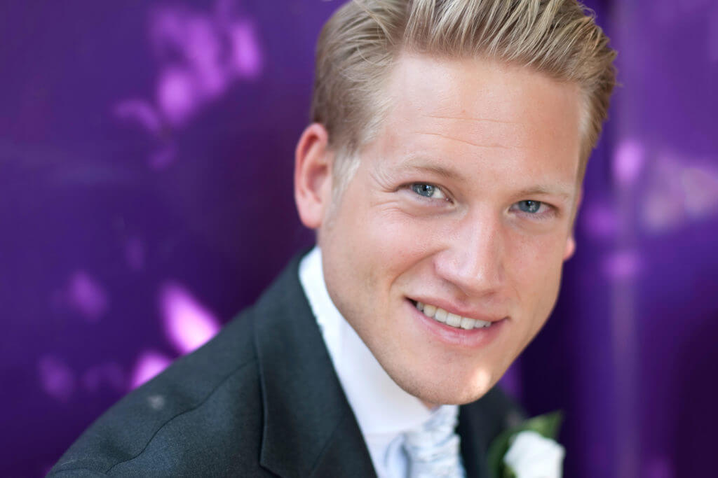 A portrait of a man against a purple background