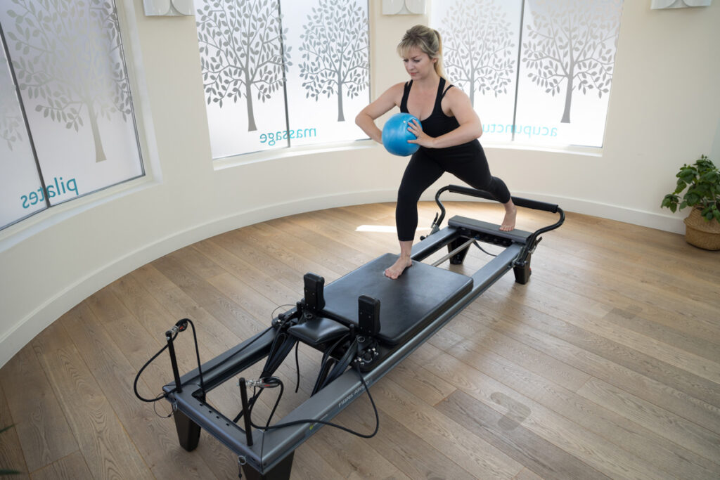 Health & Wellness Photography London. A PT demonstrating reformer pilates.