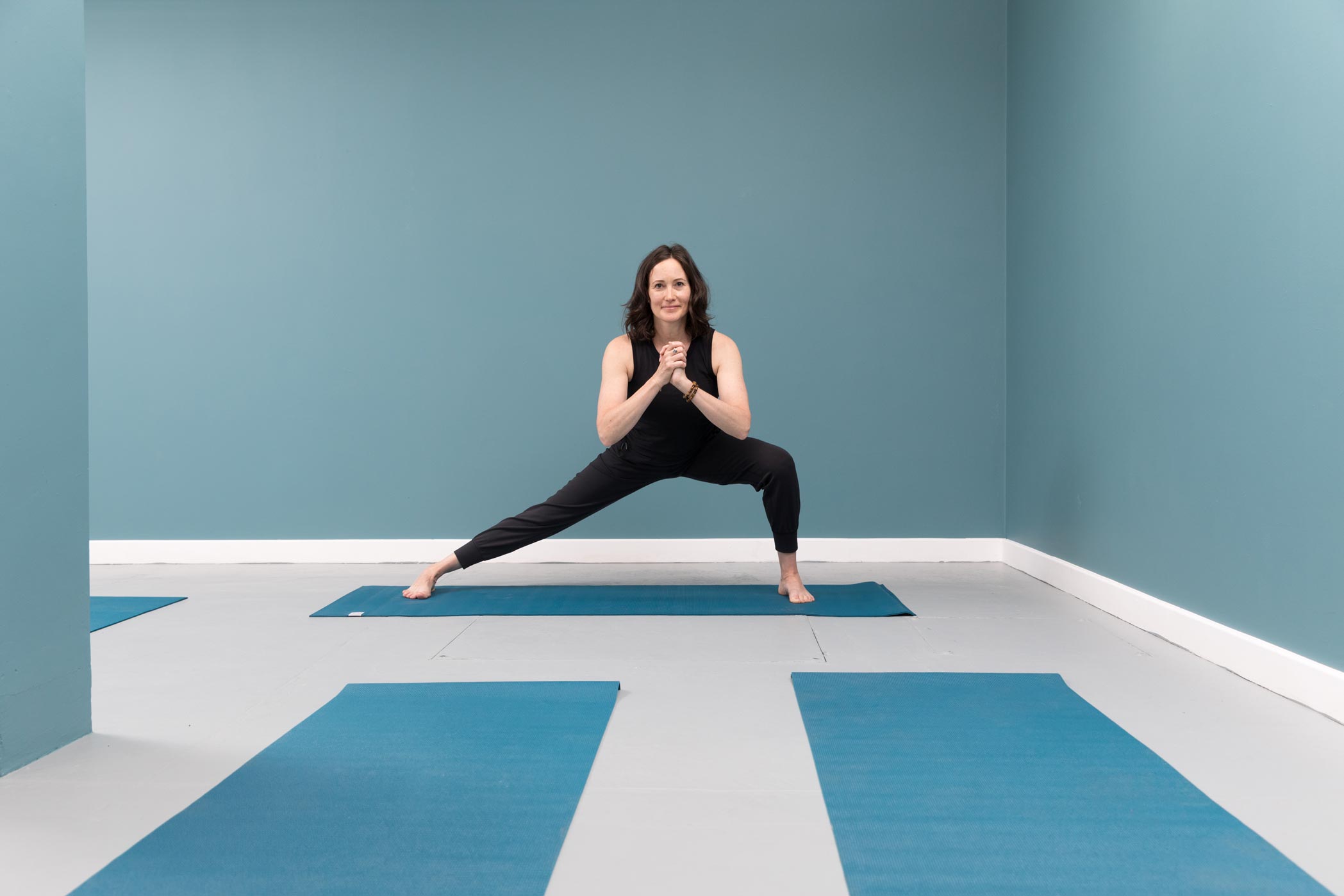 A yoga teacher practices in quiet room whilst being photographed for a personal branding