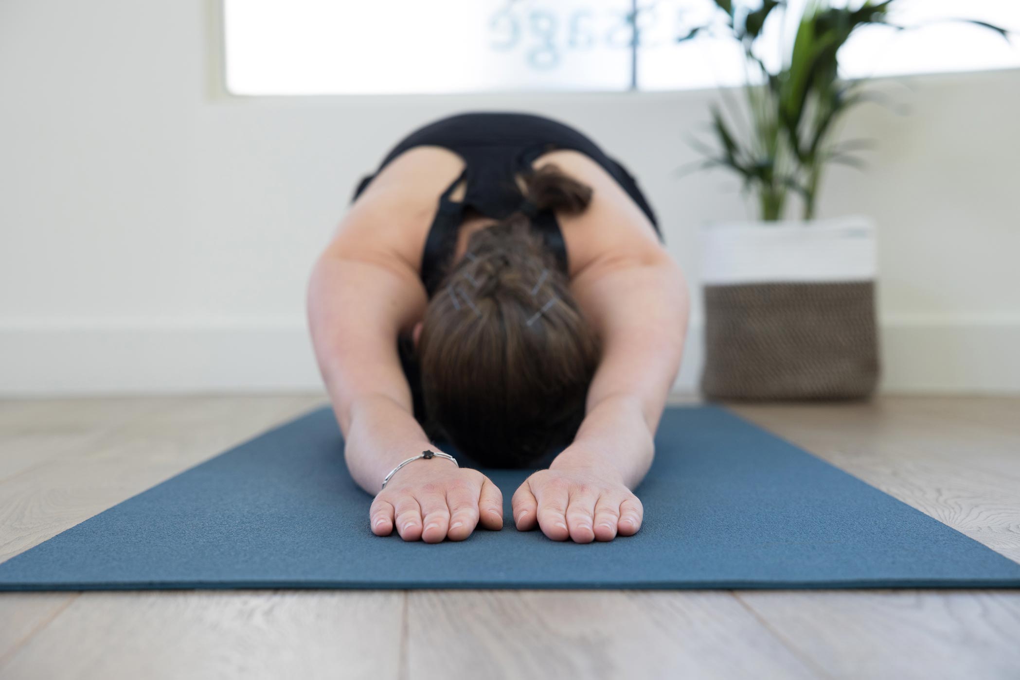 A lady relaxes on a yoga mat during a health & fitness photography photo shoot in London