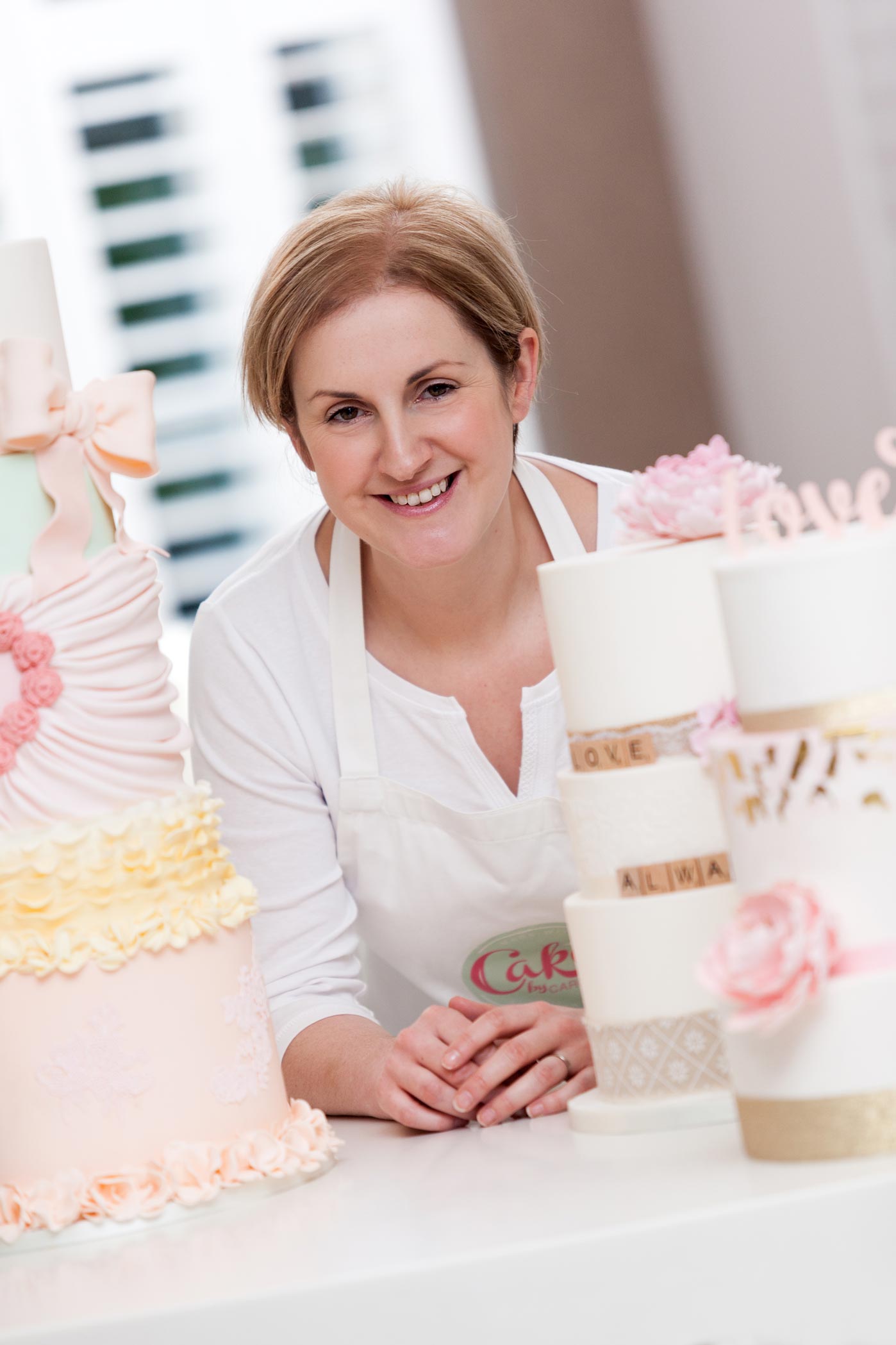 A cake makers poses with her cakes during her personal branding photography shoot in Surrey