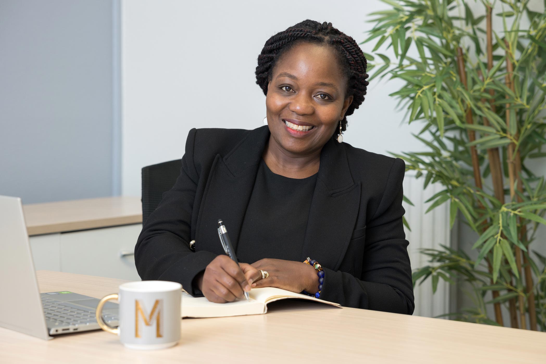 A woman smiles at the camera whilst she is working during her Croydon personal branding photography shoot