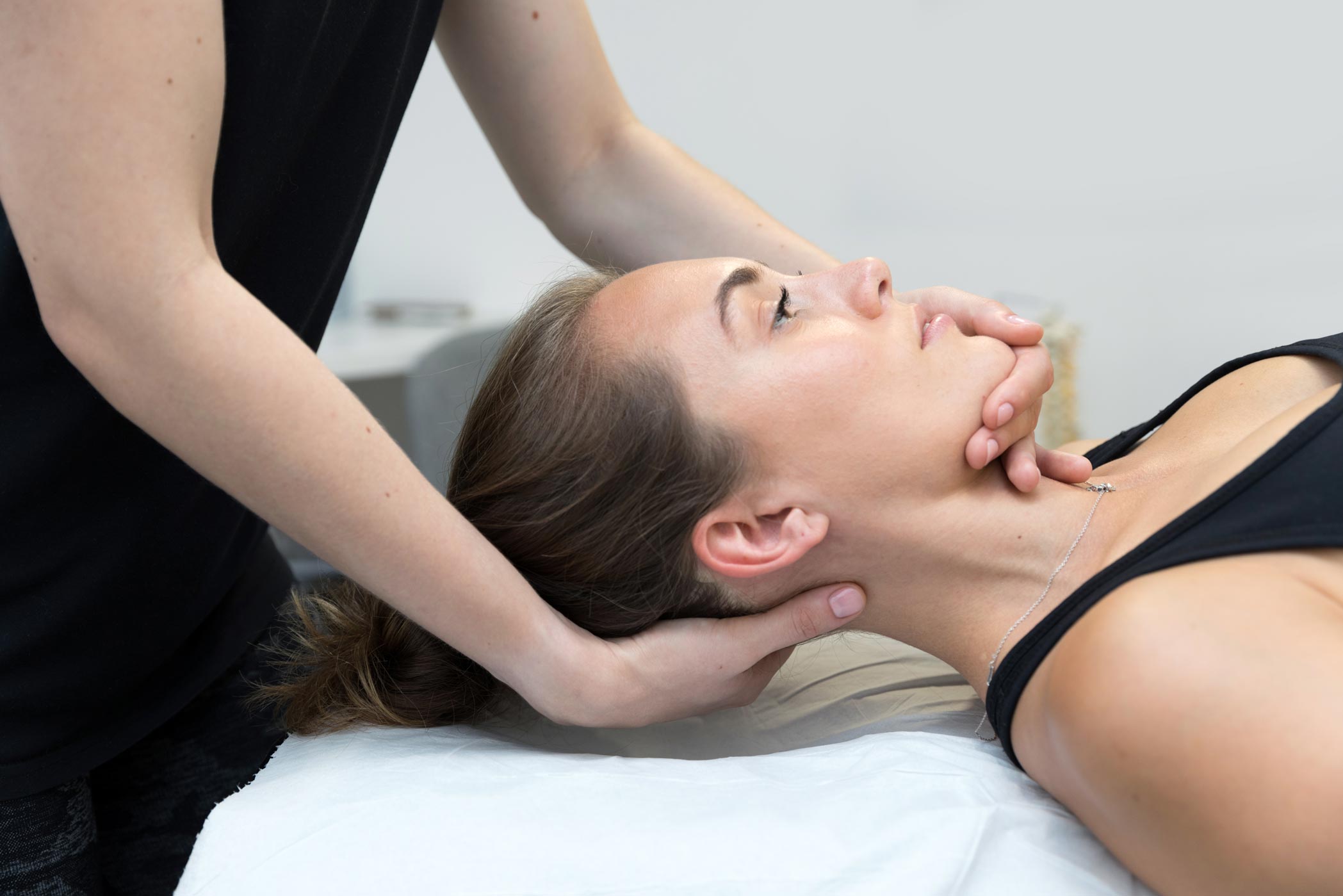 A sports massage therapist works with a patient in her Croydon clinic as part of a London health & fitness personal branding photography shoot