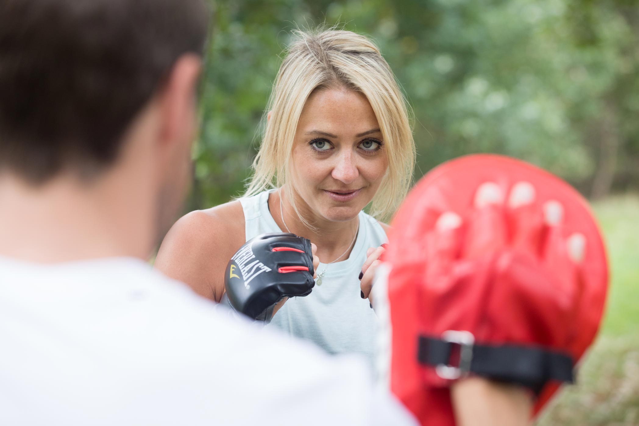 A female personal trainer boxes with a client during a fitness personal branding photography shoot in Croydon, London
