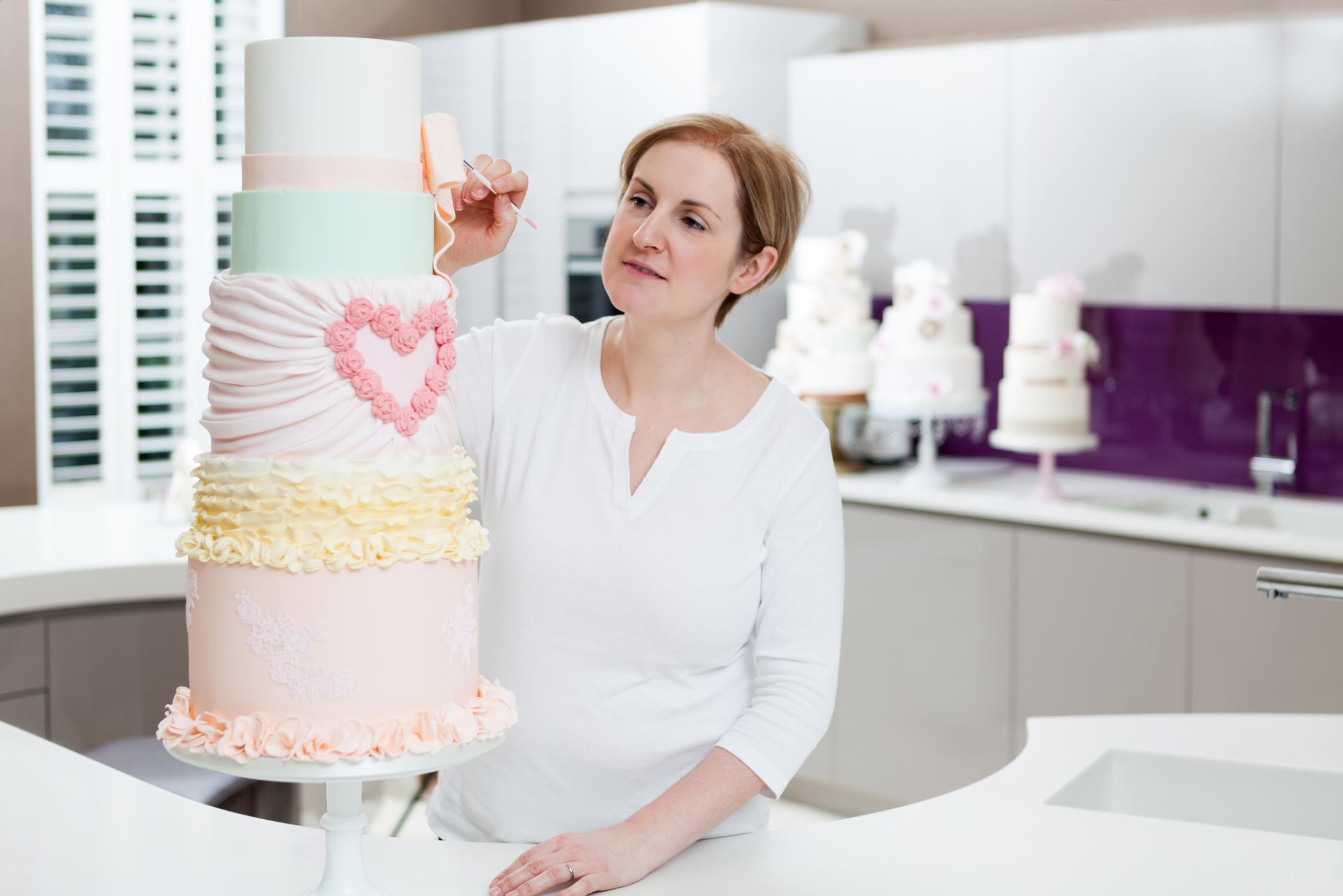 A woman decorates a wedding cake during her Surrey personal branding photography shoot