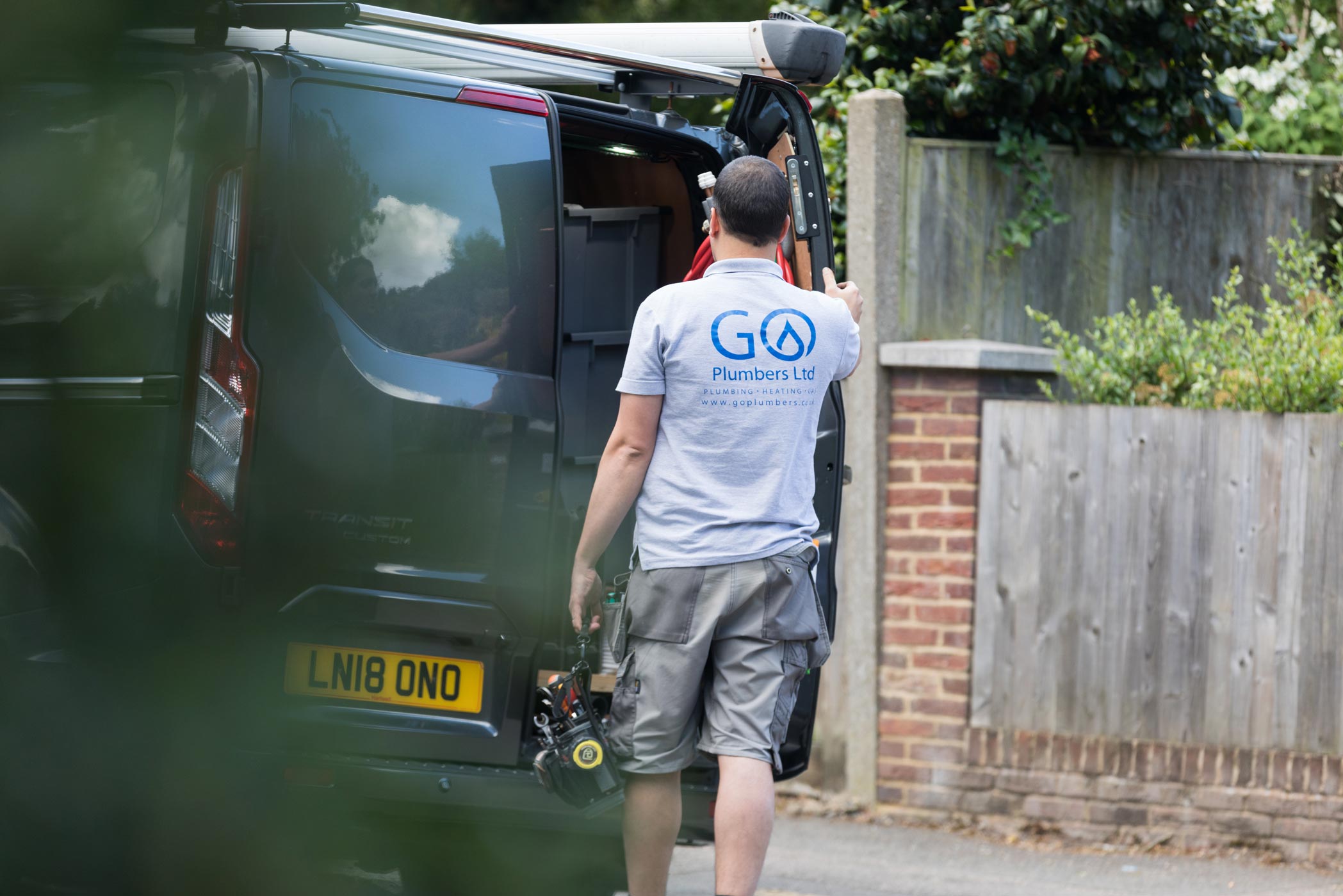 A plumer stands outside his van at his personal branding photoshoot in Croydon, Surrey