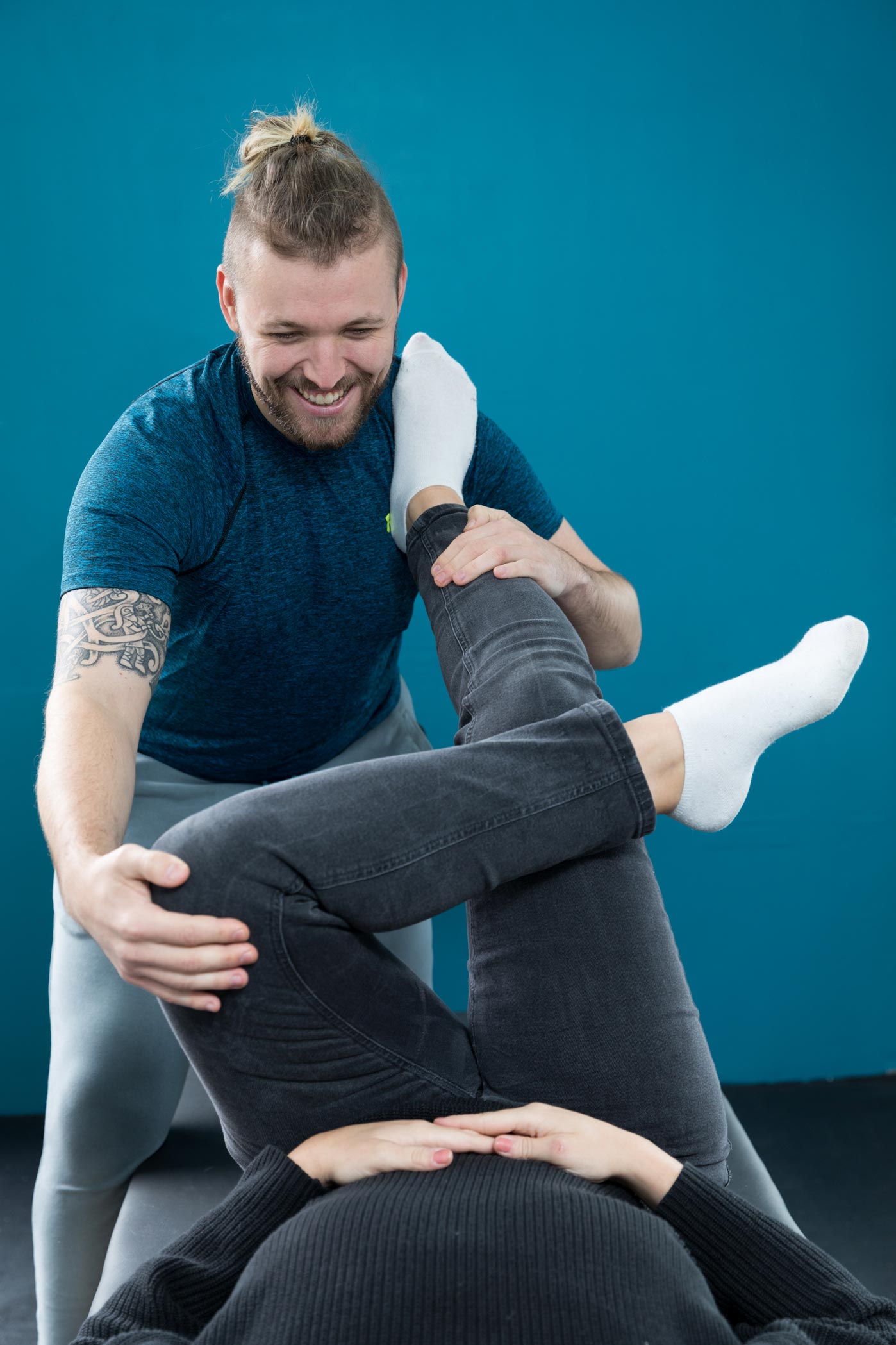 A male stretchologist stretches a client as part of a health & fitness personal branding photography shoot in Croydon, London
