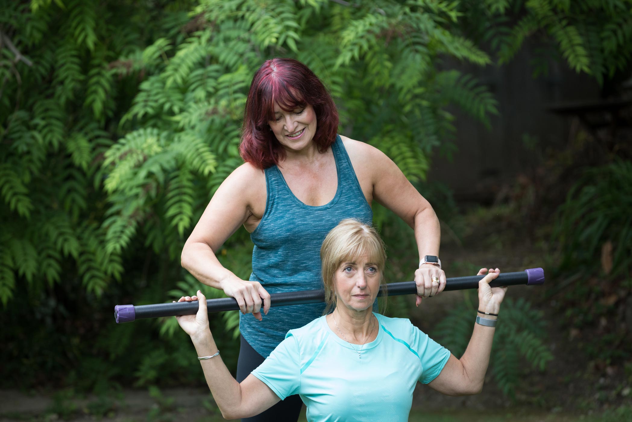A female personal trainer helps her client as part of her health & fitness personal branding photography shoot in Croydon, London