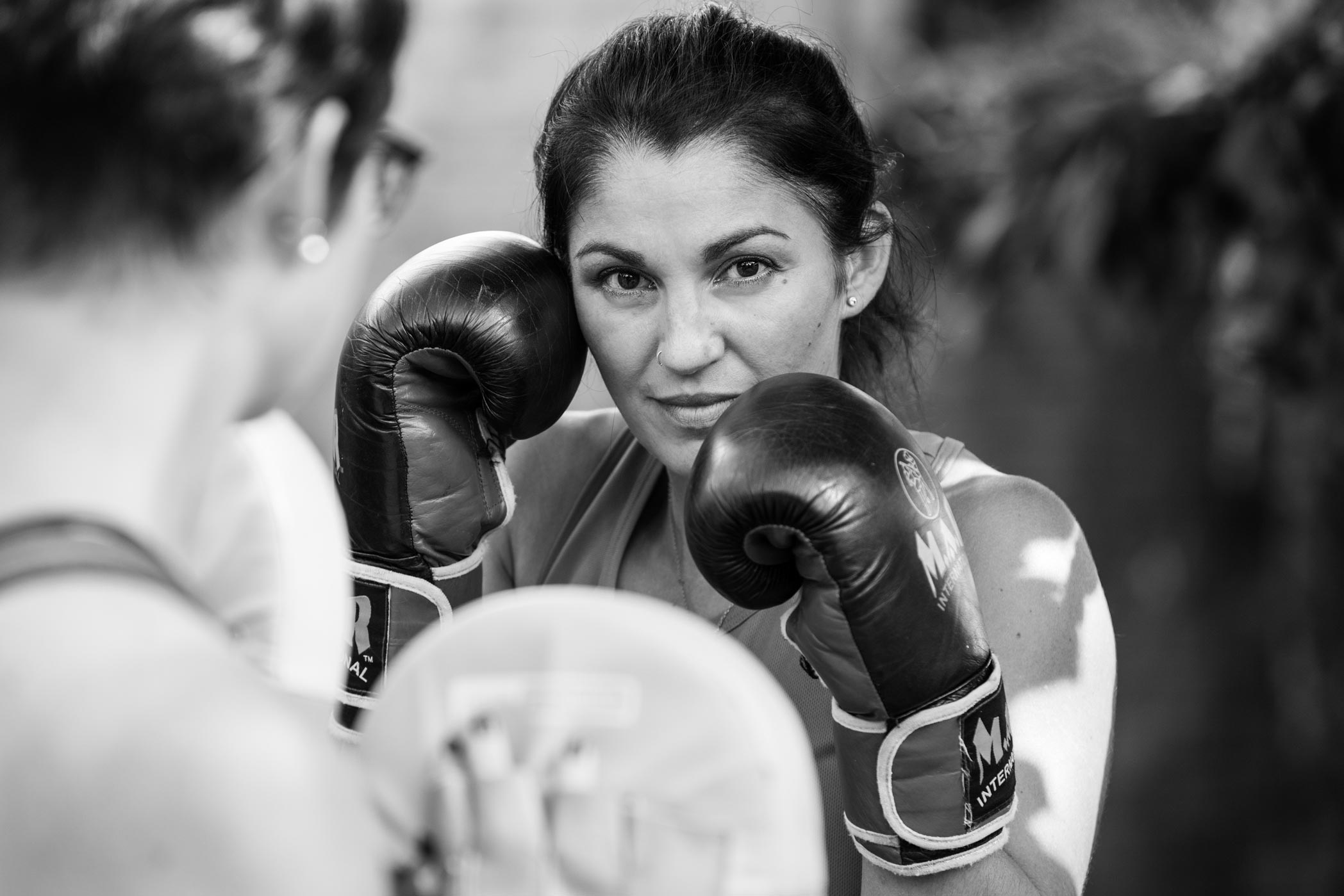 A black & white photo of a personal trainer boxing as part of her health & fitness photography shoot