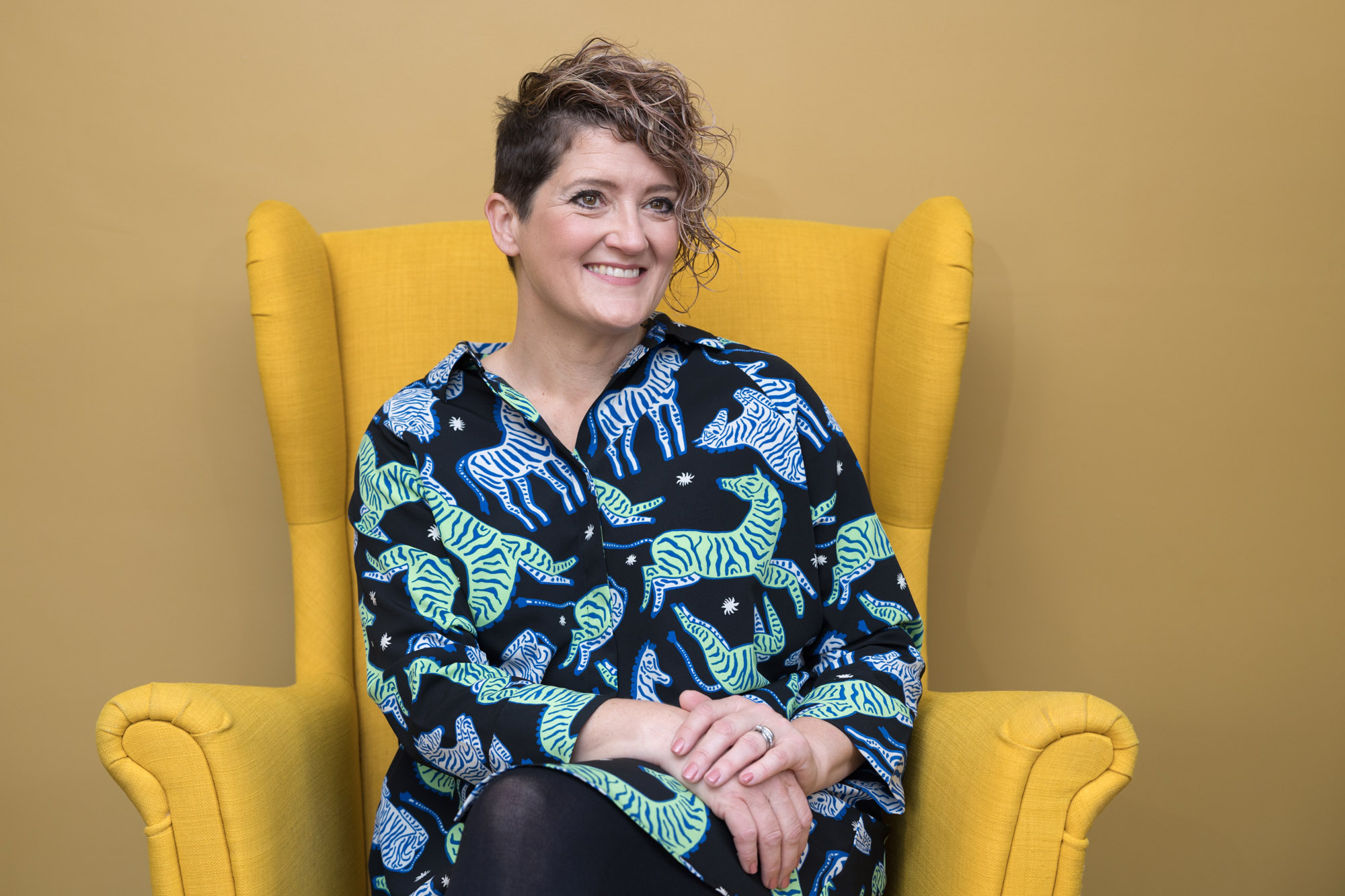 A woman sitting in yellow chair for croydon personal branding photography
