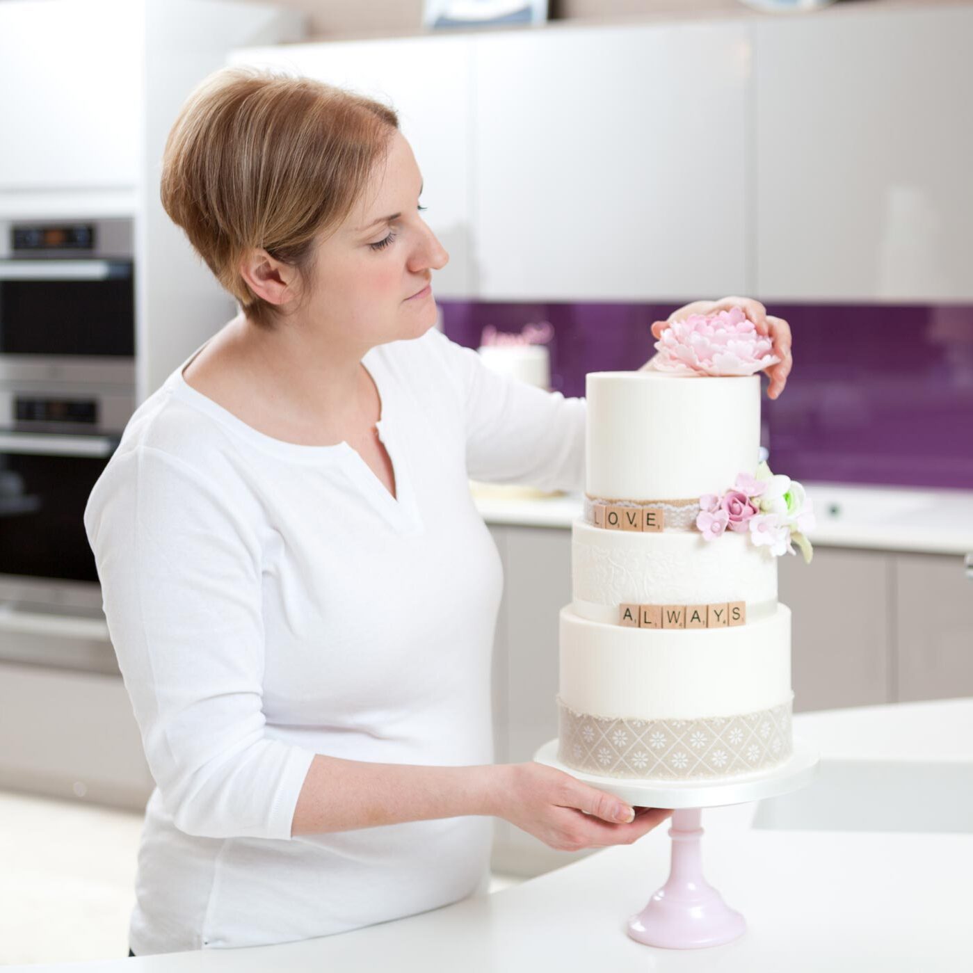 A woman decorates a wedding cake during her Surrey personal branding photography shoot