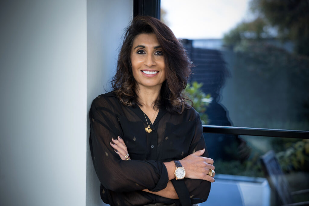 A photo of a lady wearing a black shirt and leaning against a wall illustrating an article on how to brief a photographer