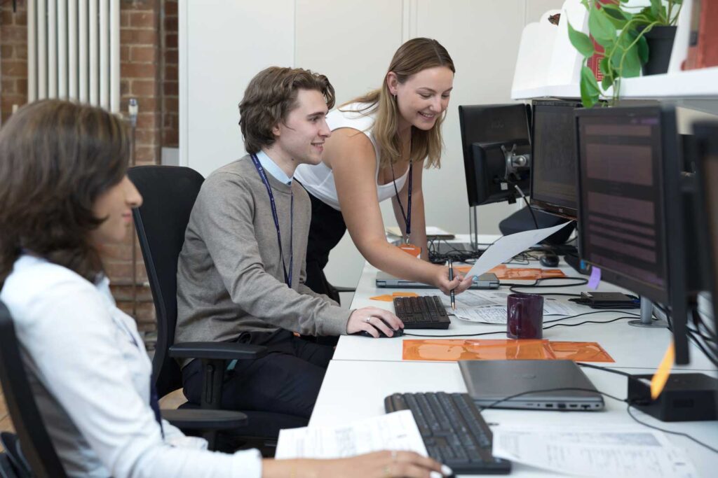 At work, an example of som corporate office lifestyle photography - three people working at desk