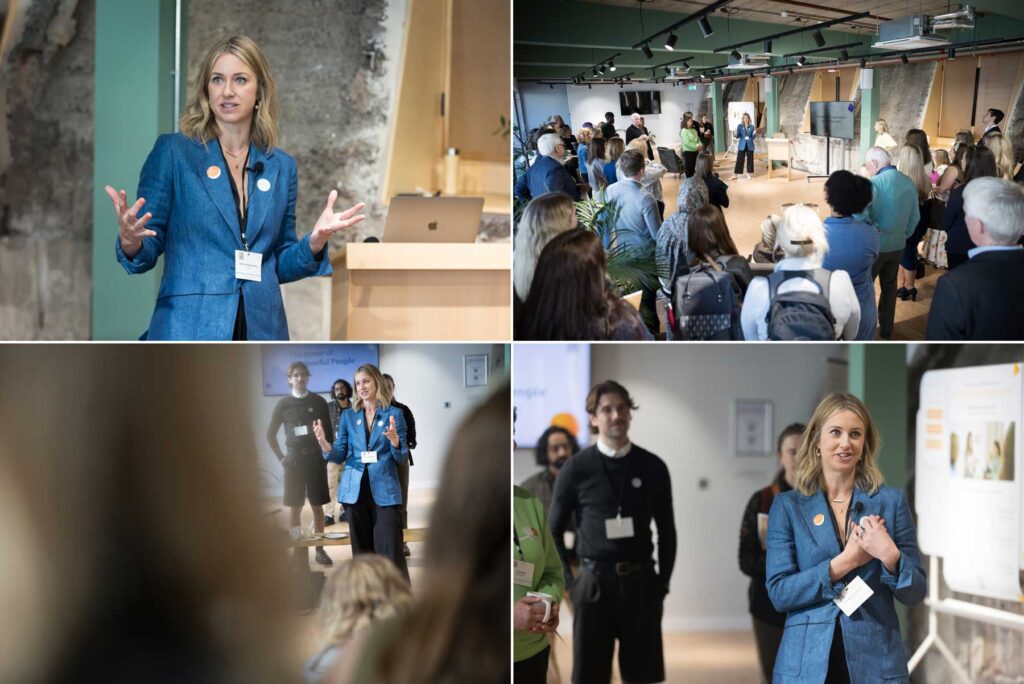 Photography showing a woman speaker at a London business event alongside the audience listening to her.